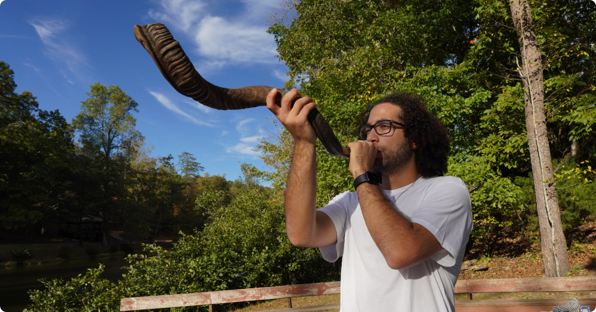 Former NFTY president Benji Rosenblum blows a shofar at Camp Coleman.