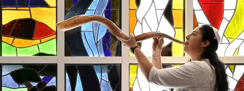 A rabbi blows a shofar.