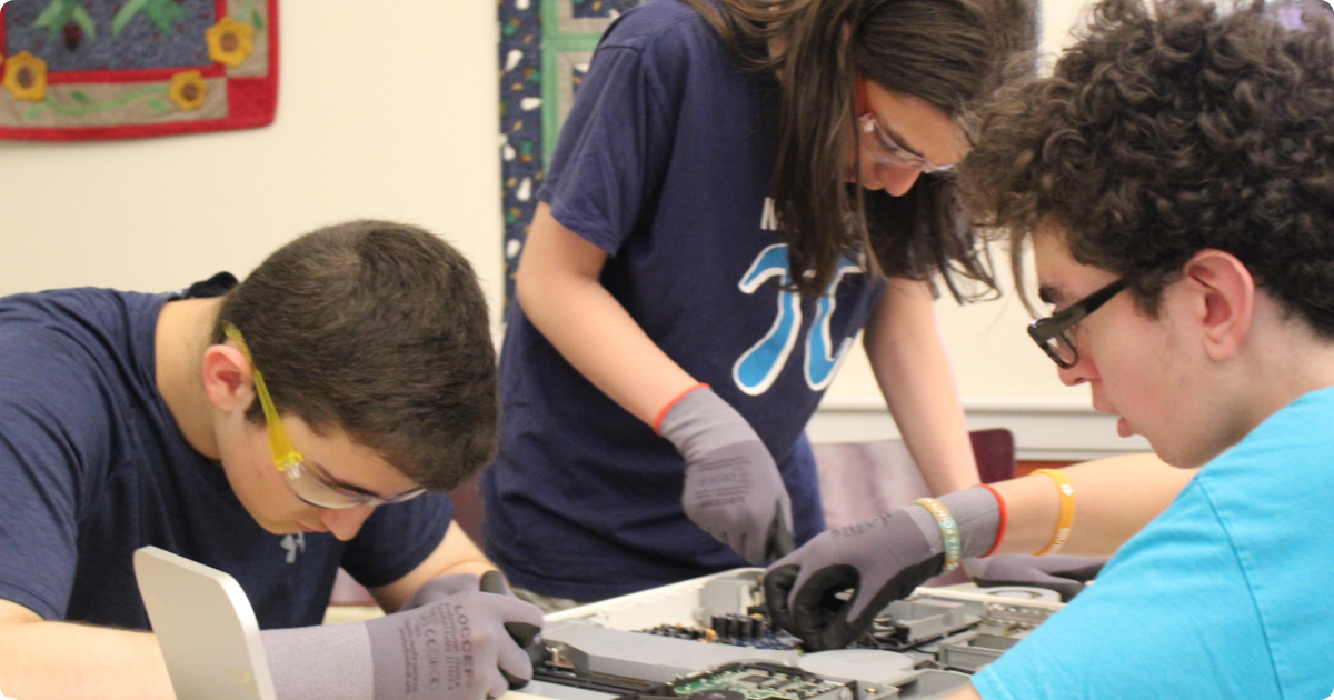 Three campers work on a science project together.